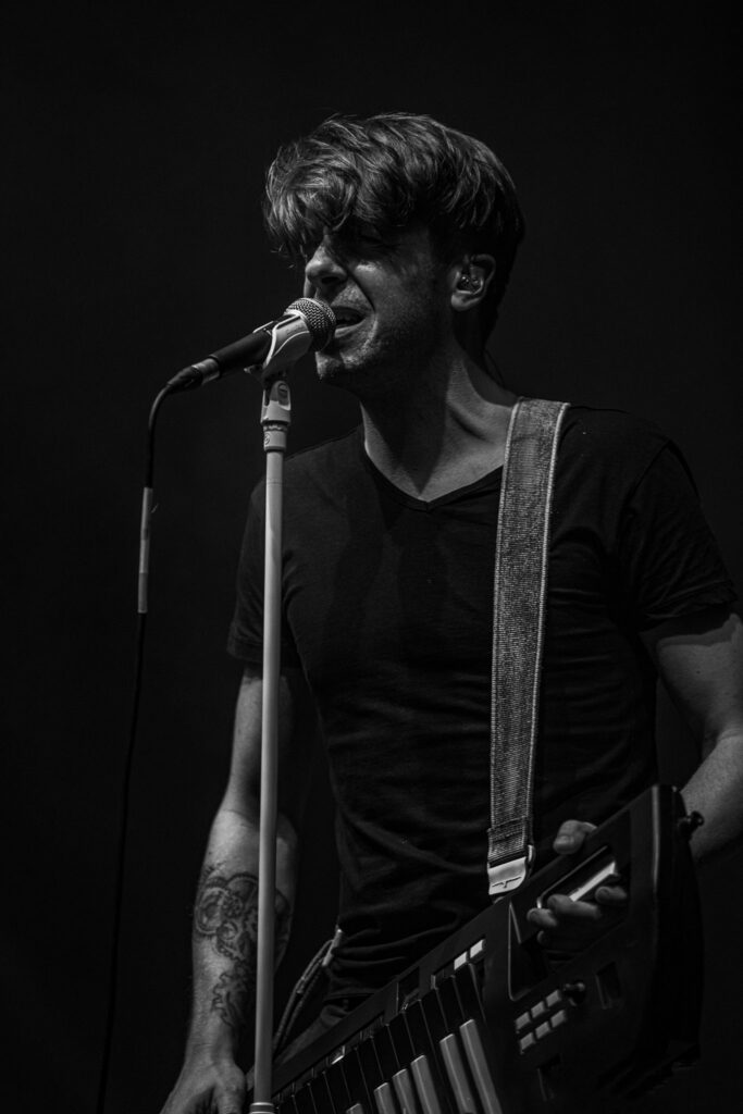 Portrait en noir et blanc d’un musicien en concert, ambiance intime et contrastée