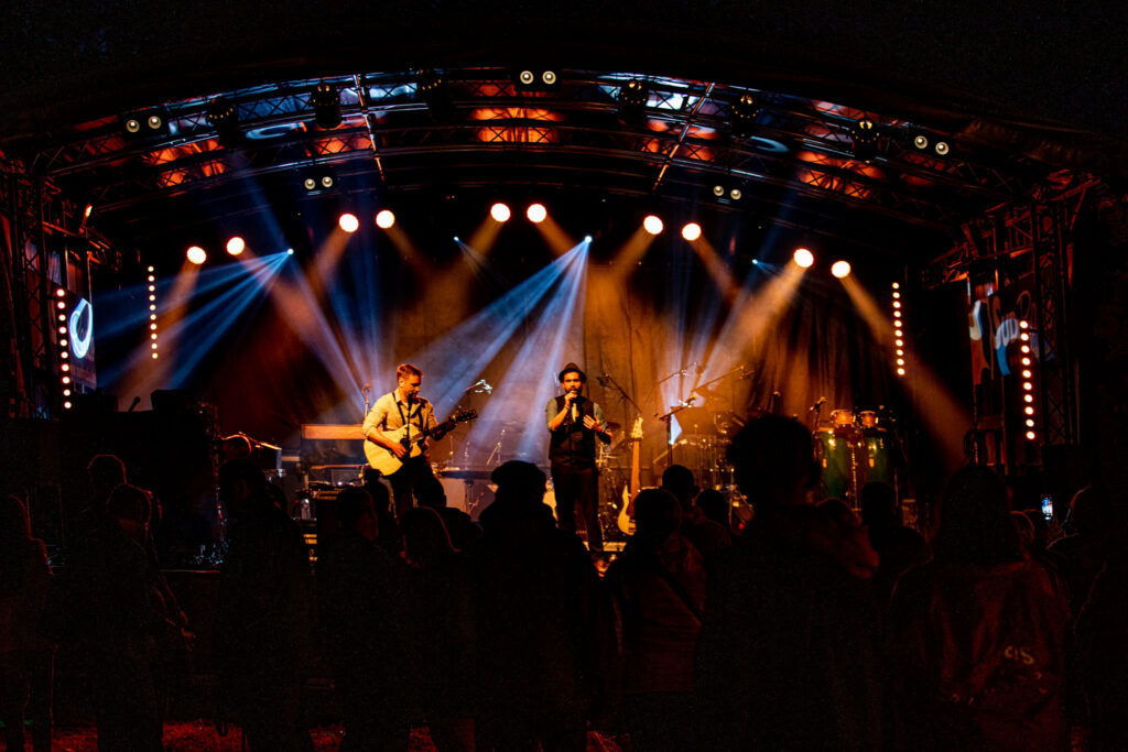 Vue du public face à la scène lors d’un concert, jeux de lumières et profondeur