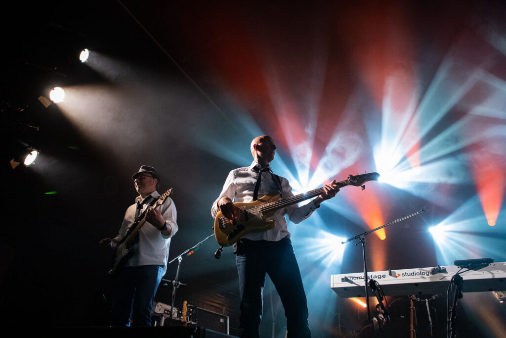 Concert live avec éclairages puissants, énergie scénique et mouvement