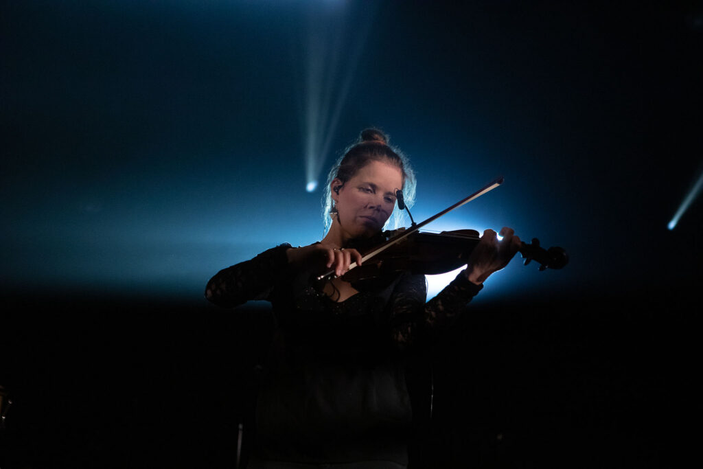 Violoniste sur scène, éclairage ciblé et moment suspendu
