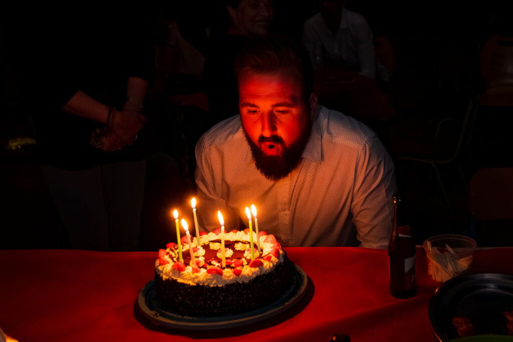 Moment fort d’un anniversaire privé avec le soufflage des bougies, éclairage intimiste et émotion sincère.