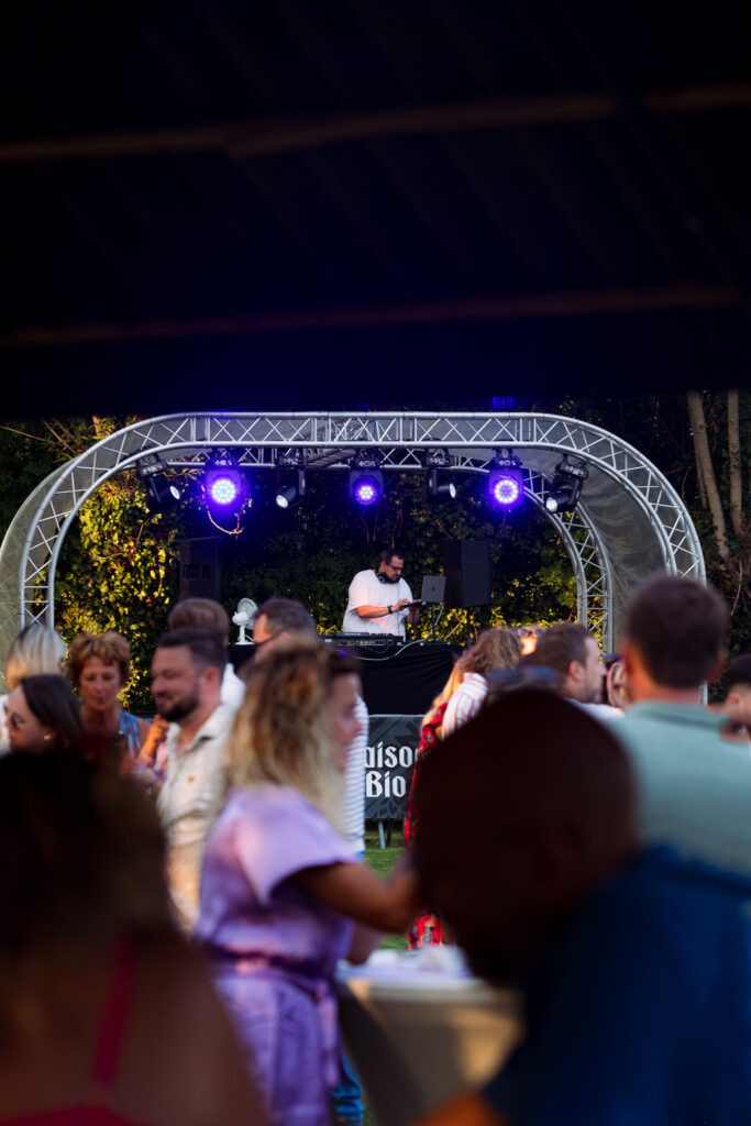 Ambiance festive lors d’une soirée musicale privée en plein air, public dansant devant la scène éclairée.