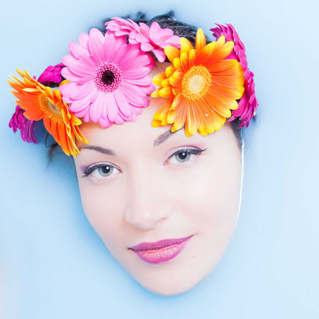 Portrait professionnel avec regard direct, image forte et lisible mettant en valeur la personnalité en bain de lait bleu